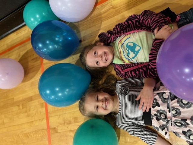 Preschool Girls laying on their backs in balloons