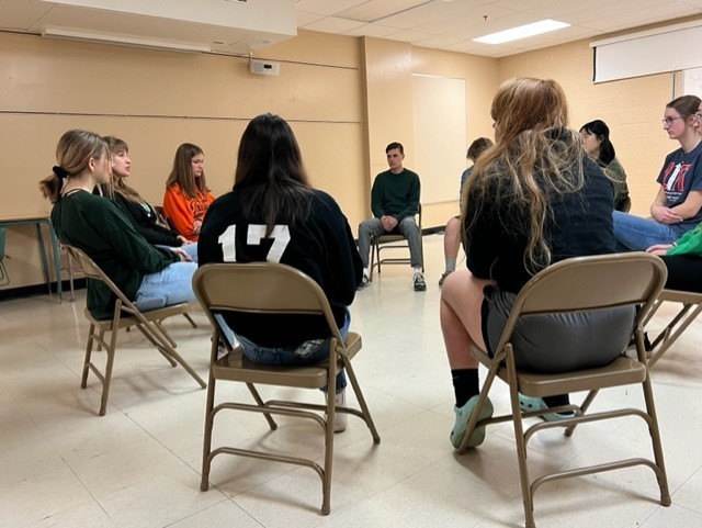 Circle of students with teacher discussing mental health