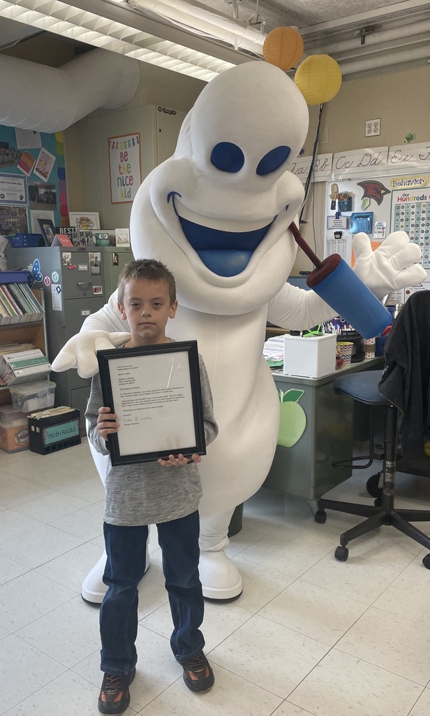Student with his letter posing with the Speedy Q mascot.